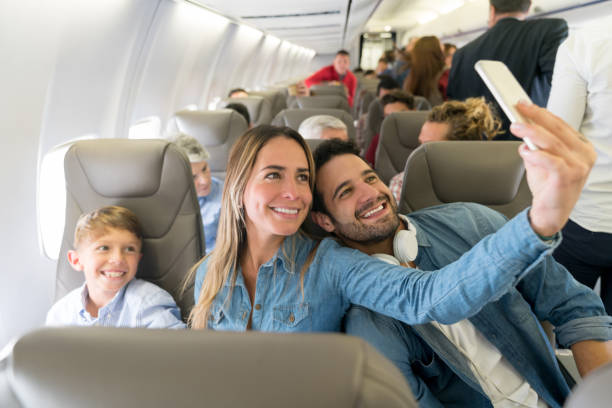 happy family traveling by plane and taking a selfie - travel stock pictures, royalty-free photos & images