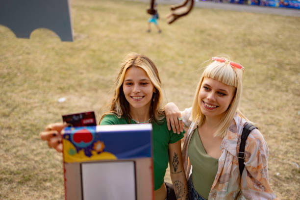 happy female friends buying drinks on a music festival. - concert stock pictures, royalty-free photos & images