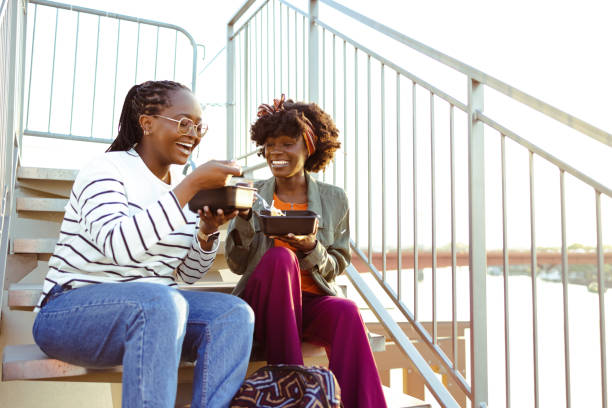 happy female friends on a lunch break - junk food stock pictures, royalty-free photos & images
