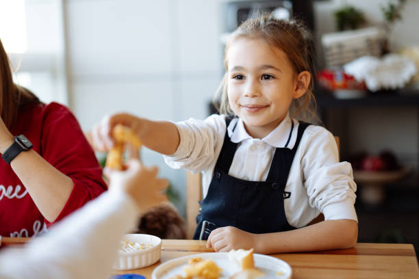 happy little girls enjoying at dinner - junk food stock pictures, royalty-free photos & images