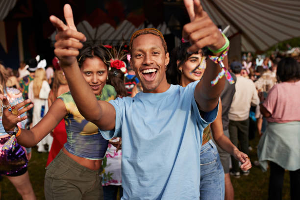 happy man gesturing while dancing with female friends - concert stock pictures, royalty-free photos & images