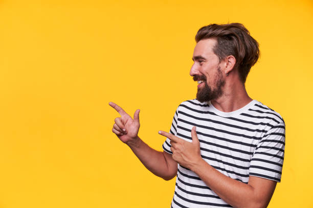 happy man pointing into a blank copy space spot with two hands. - hairstyle stock pictures, royalty-free photos & images
