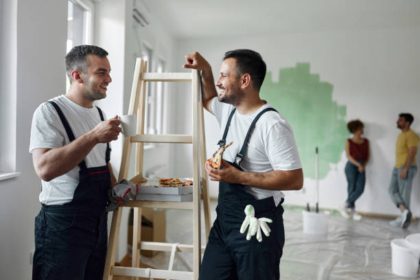 happy manual workers talking on a break inside of renovating apartment. - home decoration stock pictures, royalty-free photos & images