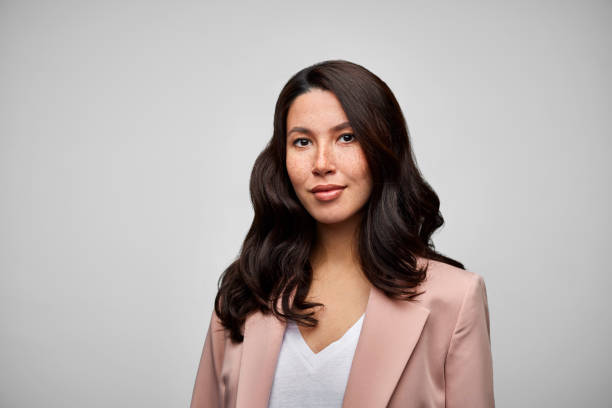 happy mixed race female brunette ceo wearing pink blazer. - hairstyle photos et images de collection