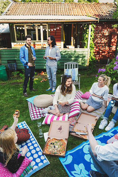 happy multi-ethnic friends having pizza in lawn during summer party - junk food stock pictures, royalty-free photos & images