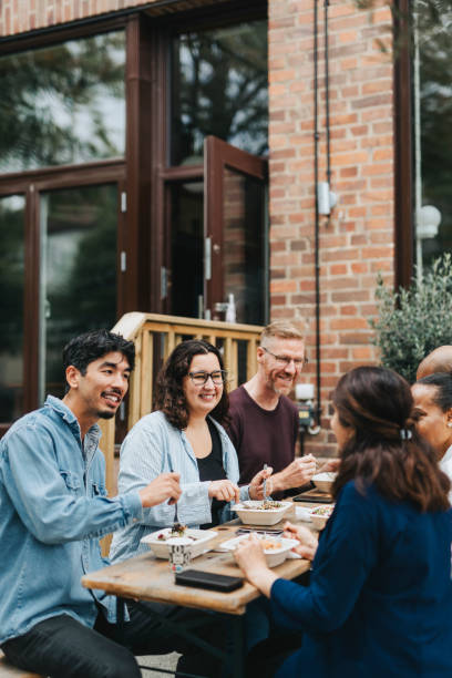 happy multiracial coworkers enjoying lunch together outside cafe - junk food stock pictures, royalty-free photos & images