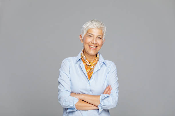 happy senior woman against grey background. - fashion stock pictures, royalty-free photos & images