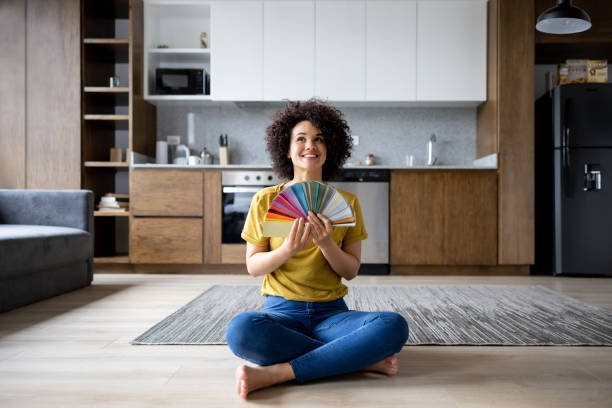 happy woman at home choosing a color to paint the walls - home decoration stock pictures, royalty-free photos & images