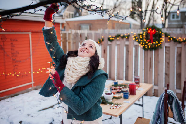 happy woman decorating backyard with illuminated lighting equipments - garden decoration stock pictures, royalty-free photos & images