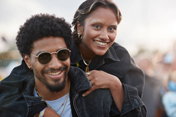 happy woman enjoying piggyback ride on boyfriend - concert stock pictures, royalty-free photos & images