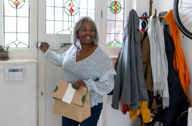 happy woman receiving a food delivery at home - junk food stock pictures, royalty-free photos & images