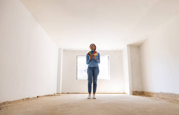 happy woman remodeling her house and choosing a color for the walls - home decoration stock pictures, royalty-free photos & images
