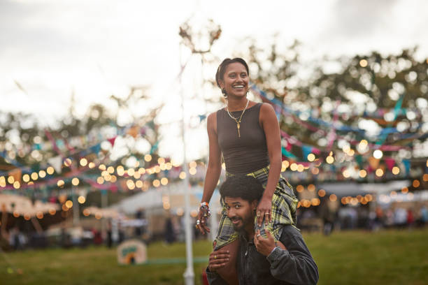 happy woman sitting on boyfriend's shoulders - concert stock pictures, royalty-free photos & images