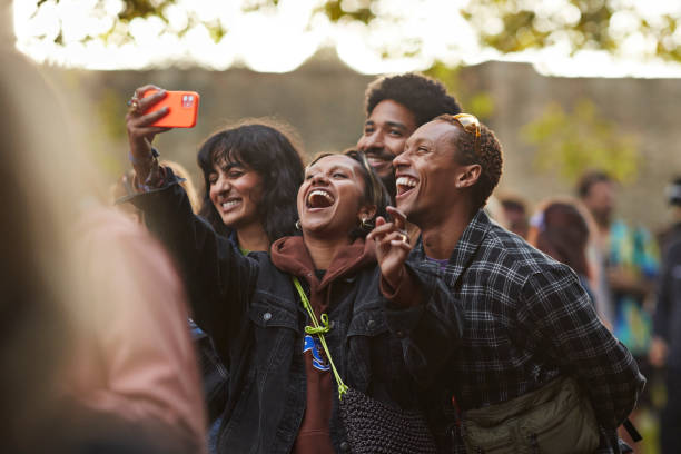 happy woman taking selfie with friends through smart phone - concert stock pictures, royalty-free photos & images