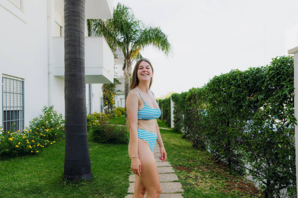happy woman walking in tropical garden among palm trees - garden decoration stock pictures, royalty-free photos & images