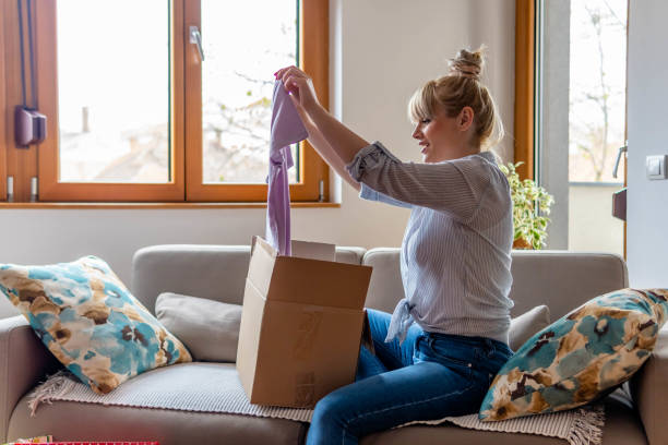 happy young attractive woman open cardboard box satisfied with purchase online shop order sit on sofa at home. - fashion stock pictures, royalty-free photos & images