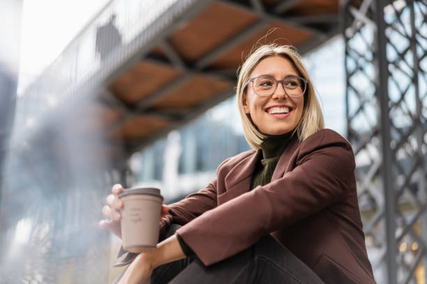 happy young businesswoman with takeaway coffee in the city - junk food stock pictures, royalty-free photos & images