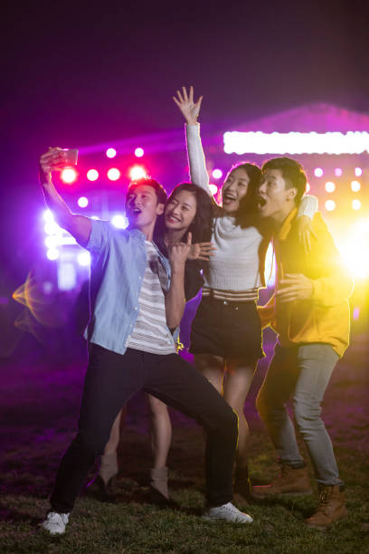 happy young chinese friends taking selfie at music festival - concert stock pictures, royalty-free photos & images