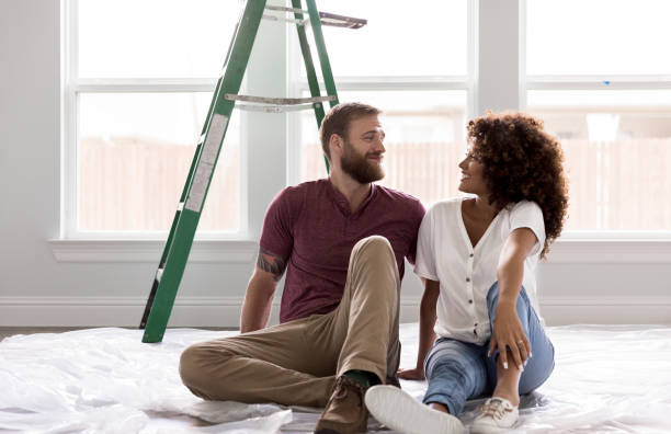 happy young couple take break from diy project - home decoration stock pictures, royalty-free photos & images