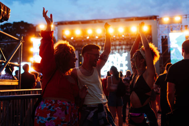 happy young friends dancing at music festival at night - concert stock pictures, royalty-free photos & images