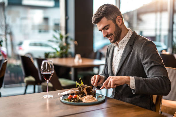 happy young man eating lunch at a restaurant. - food stockfoto's en -beelden