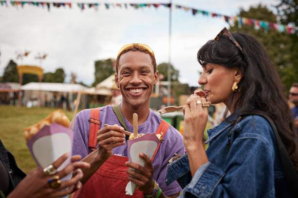 happy young man sharing dessert with female friend - junk food stock pictures, royalty-free photos & images