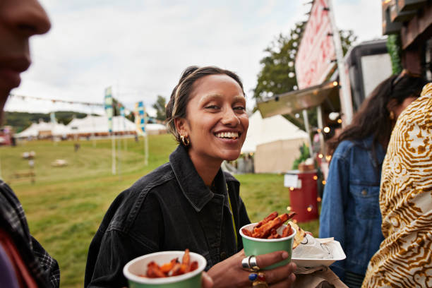 happy young woman holding street food - junk food stock pictures, royalty-free photos & images