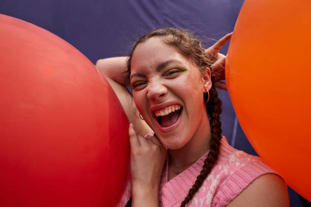 happy young woman with red and orange balloons - fashion stock pictures, royalty-free photos & images