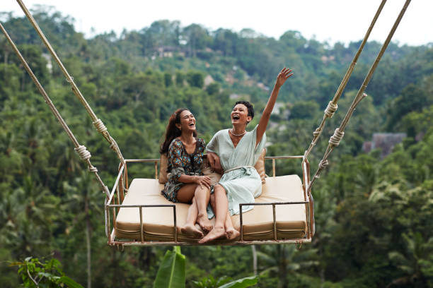 happy young women enjoying swinging during vacation - travel stock pictures, royalty-free photos & images