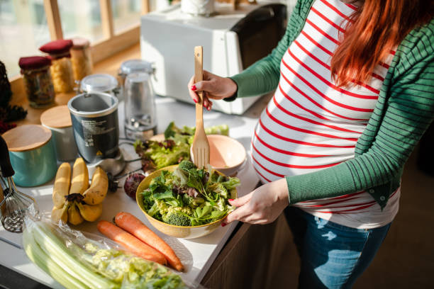 healthy pregnant woman preapring a fresh organic salad for her breakfast - food stock pictures, royalty-free photos & images