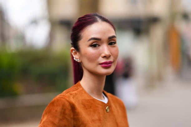 Heart Evangelista wears white gold diamond earrings, dark brown buttoned suede Akris blazer jacket, outside Akris, during the Paris Fashion week...