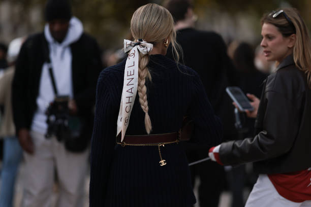 Helena Bordon is seen wearing a blue blazer with a brown belt and a gold narrow belt by Chanel, plus a white hairband by Chanel with a bow in her...