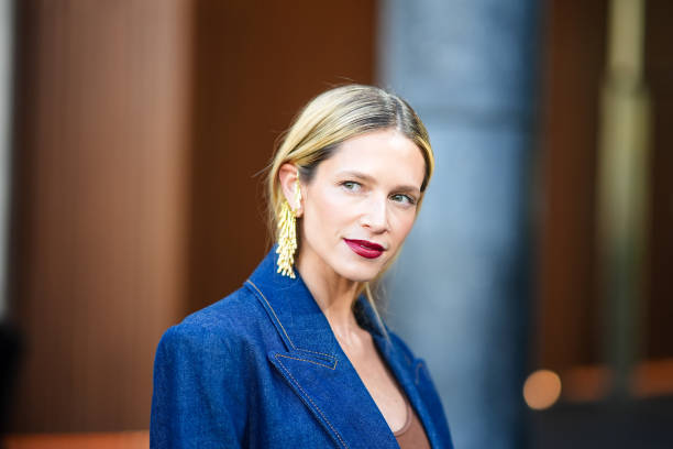Helena Bordon wears a brown / orange top, a blue denim jacket, gold earrings, outside Zimmermann, during the Womenswear Fall/Winter 2024/2025 as part...