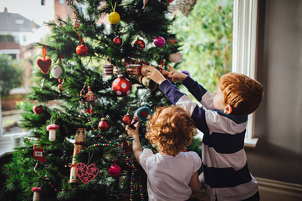 helping mum with the tree - home decoration stock pictures, royalty-free photos & images