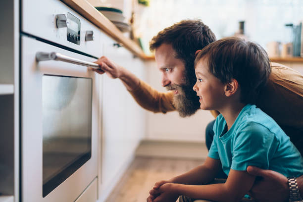 het kokenvan de vader en van de zoon diner thuis - food stockfoto's en -beelden