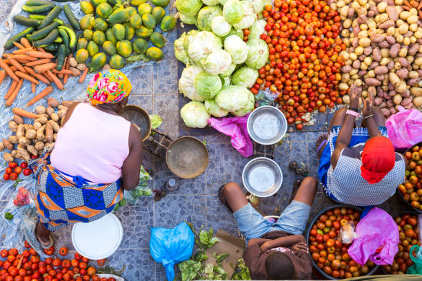 high angle view of vendors selling a selection of fresh vegetables on a street market. - food stock pictures, royalty-free photos & images