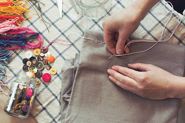 high angle view of woman stitching fabric on table at home - fashion stock pictures, royalty-free photos & images