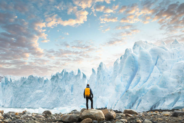 hiker admiring the perito moreno glacier at sunset, argentina - travel stock pictures, royalty-free photos & images