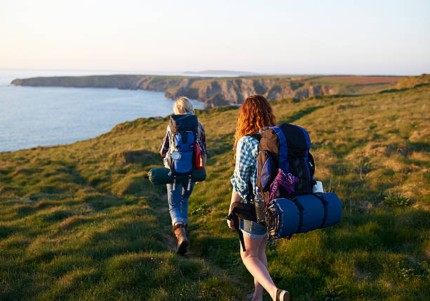hikers walking along coastal path - travel stock pictures, royalty-free photos & images