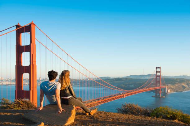 hispanic couple admiring golden gate bridge, san francisco, california, united states - travel stock-fotos und bilder
