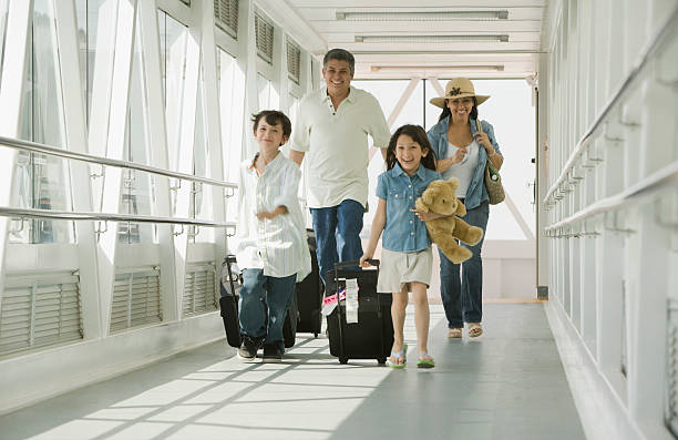 hispanic family walking through airport - travel stockfoto's en -beelden