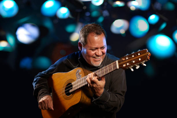 hispanic man playing guitar for crowd - concert stock pictures, royalty-free photos & images
