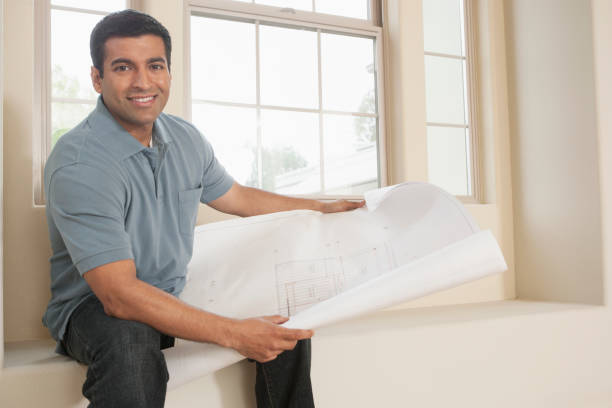 hispanic man reading blueprints in new home - home decoration stock pictures, royalty-free photos & images