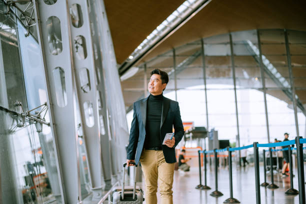 homme d’affaires marchant dans le passage de l’aéroport - travel photos et images de collection