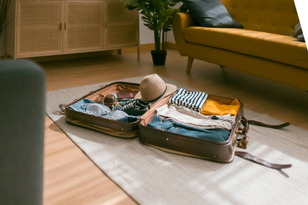 horizontal view of an open suitcase full of clothes ready to travel. - travel stock pictures, royalty-free photos & images