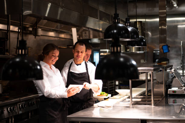 hospitality team discussing bookings on a tablet - food stock pictures, royalty-free photos & images