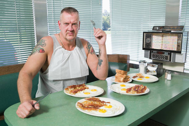 hostile man with plates of fried food - junk food stock pictures, royalty-free photos & images