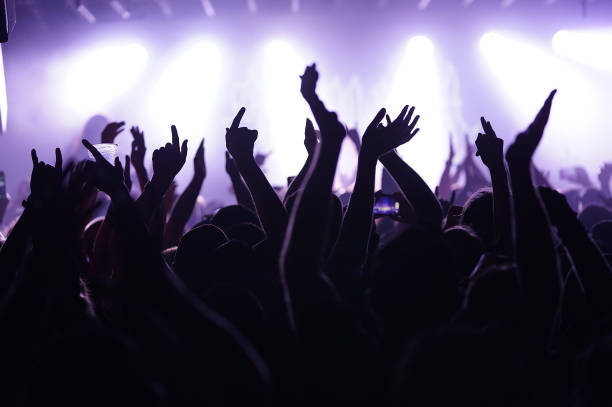 human hands against a lit background. - concert stock pictures, royalty-free photos & images