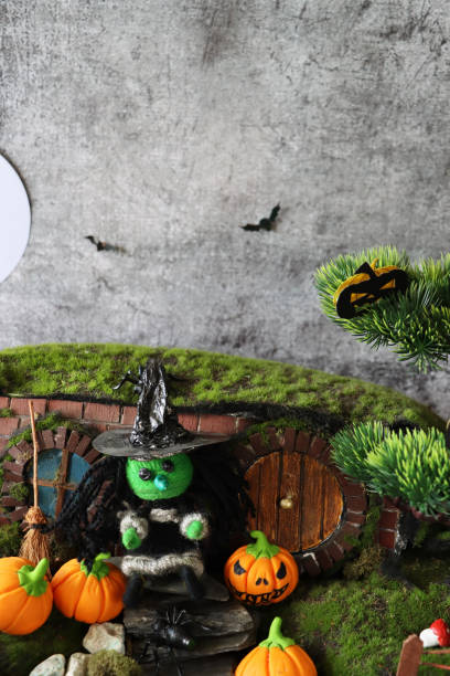 image of witch's house and garden night scene, string witch stood beside broom on slate paddle stone steps, orange fondant icing pumpkin jack o'lanterns, artificial grass - garden decoration stock pictures, royalty-free photo
