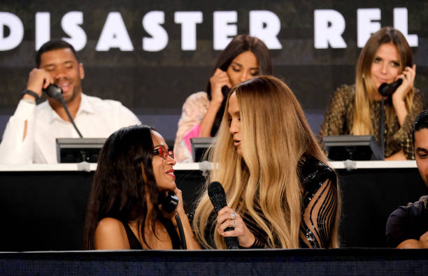 In this handout photo provided by One Voice: Somos Live!, actor Zoe Saldana and singer Jennifer Lopez speak onstage during "One Voice: Somos Live! A...